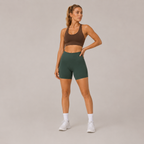 Model posing in the dark green Fitfigura Seamless Short – Athletic Form, highlighting the fitted waistband and sculpted short design.