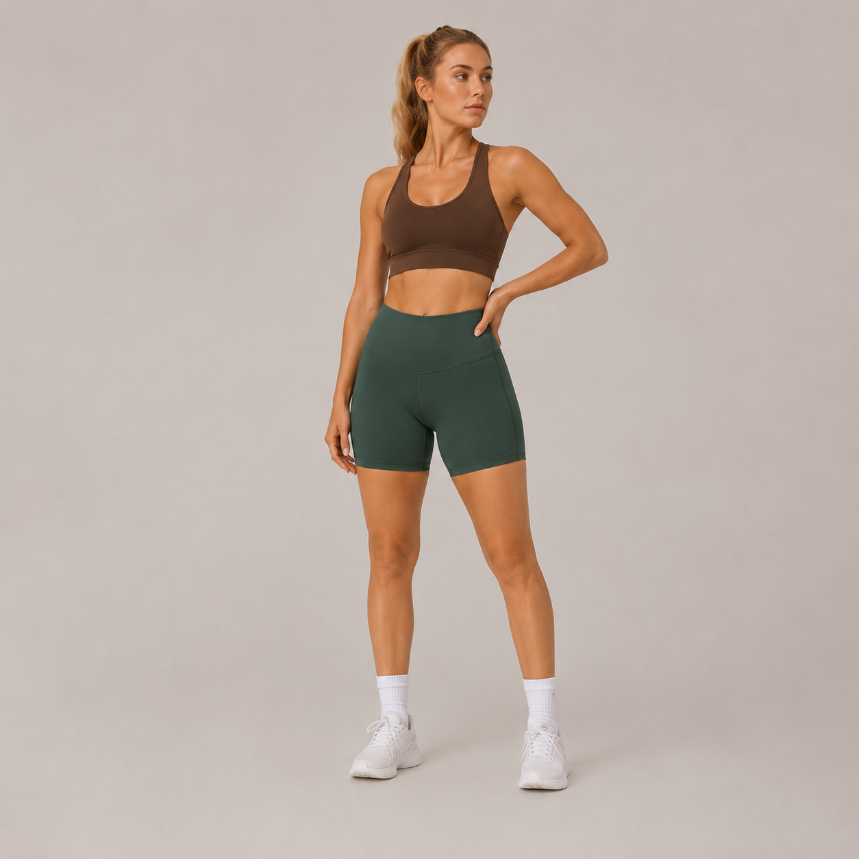 Model posing in the dark green Fitfigura Seamless Short – Athletic Form, highlighting the fitted waistband and sculpted short design.