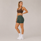 Side-angle view of the Fitfigura Seamless Short – Athletic Form in dark green, showing the high-waisted fit and smooth athletic silhouette.