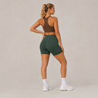 Three-quarter rear angle of the Fitfigura Seamless Short – Athletic Form in dark green, highlighting the contour fit and seamless finish.