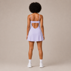 Back view of the Fitfigura Serve Dress – Elite Court Form in light purple, showing the rear strap detail and flared dress silhouette.
