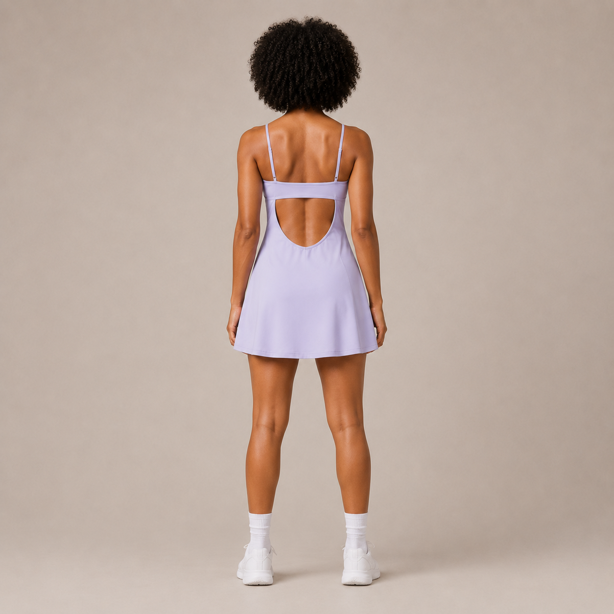 Back view of the Fitfigura Serve Dress – Elite Court Form in light purple, showing the rear strap detail and flared dress silhouette.
