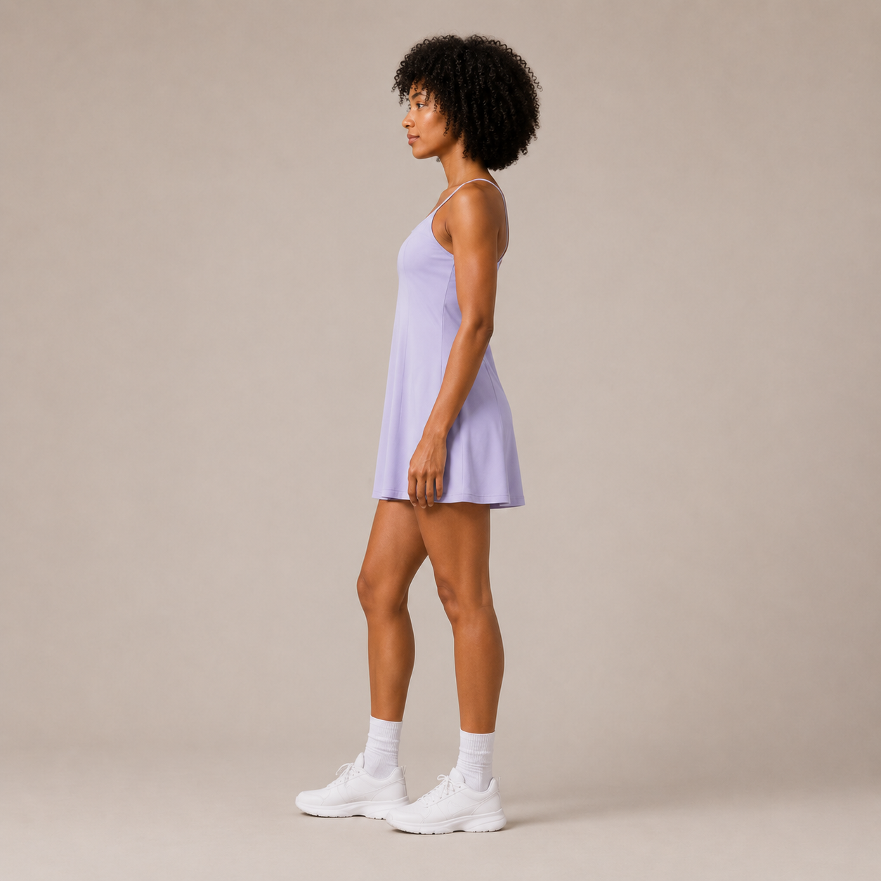 Side view of the Fitfigura Serve Dress – Elite Court Form in light purple, showing the sleeveless cut and softly flared dress shape.