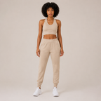 Model wearing the Fitfigura Soft Ribbed Set – Luxe Comfort Form in cream, featuring a sleeveless crop top and relaxed jogger pants, shown from the front.