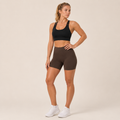 Model wearing the Fitfigura Studio Bra – Soft Flow in black with fitted shorts, showing the supportive front fit and soft activewear silhouette.