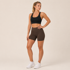 Model wearing the Fitfigura Studio Bra – Soft Flow in black with fitted shorts, showing the supportive front fit and soft activewear silhouette.