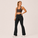 Model posing in the black Fitfigura Studio High Waist Flare Pant – Fluid Motion Form, highlighting the sculpted waist and fluid flared silhouette.