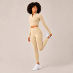 Model wearing the cream Fitfigura Studio Set – Soft Flow Form in a leg-lift pose, highlighting the flexible activewear fit.