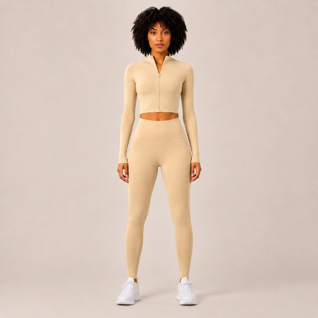 Model wearing the Fitfigura Studio Set – Soft Flow Form in cream, featuring a zip-front long sleeve crop top and matching leggings, shown from the front.