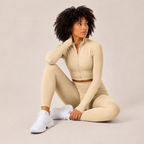Model seated in the cream Fitfigura Studio Set – Soft Flow Form, showing the soft fitted leggings and zip-front crop top.