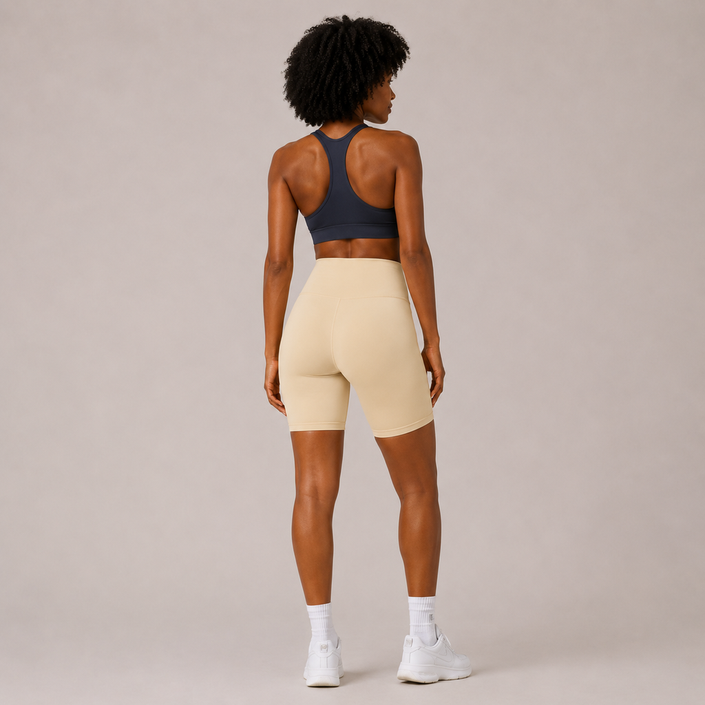 Back view of the cream Fitfigura Studio Short 8” – Flow Essential Form, showing the fitted rear shape and smooth waistband.
