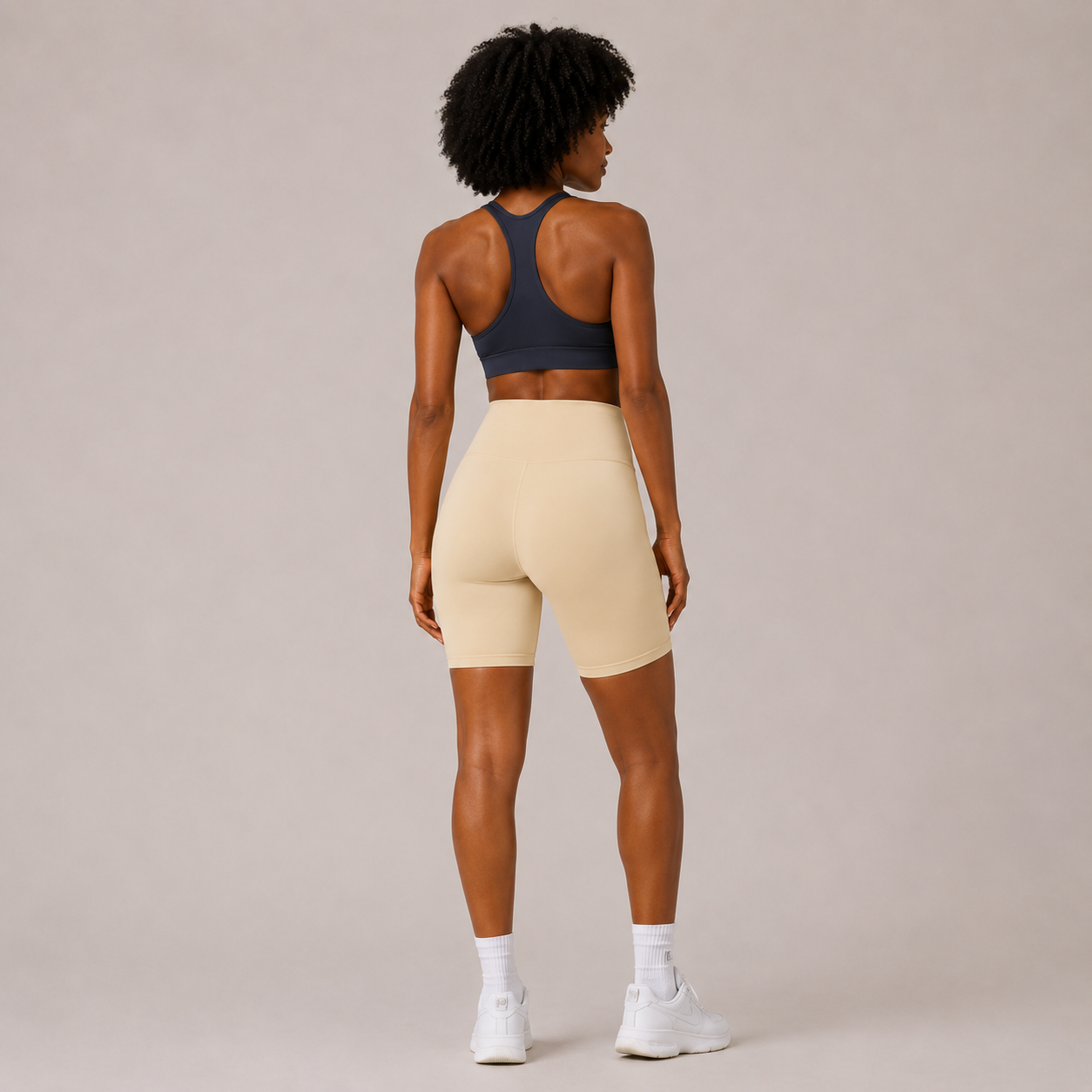 Back view of the cream Fitfigura Studio Short 8” – Flow Essential Form, showing the fitted rear shape and smooth waistband.