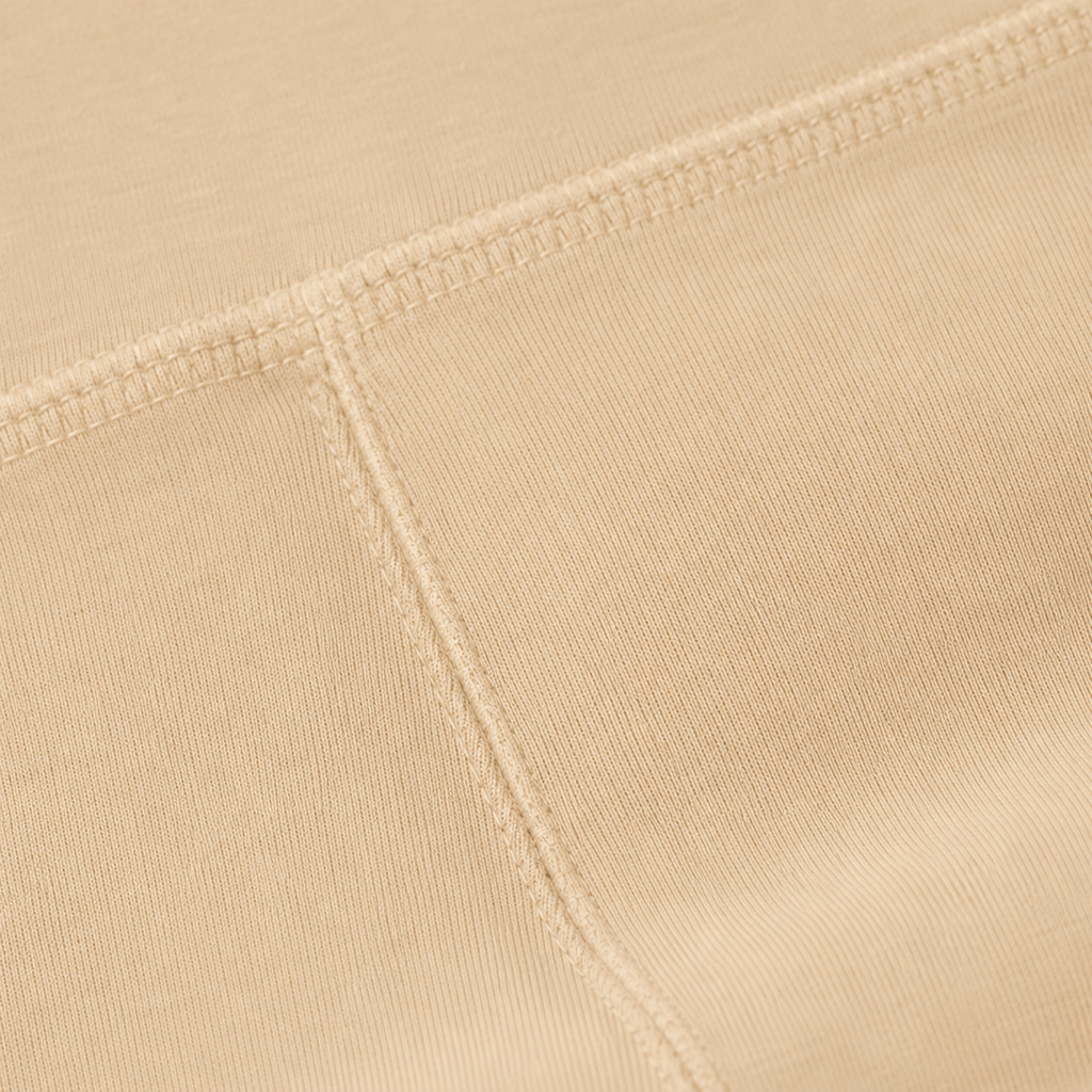 Close-up of the cream fabric and seam detail used in the Fitfigura Studio Short 8” – Flow Essential Form.