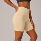 Close-up side view of the cream Fitfigura Studio Short 8” – Flow Essential Form showing the smooth fabric and contoured silhouette.