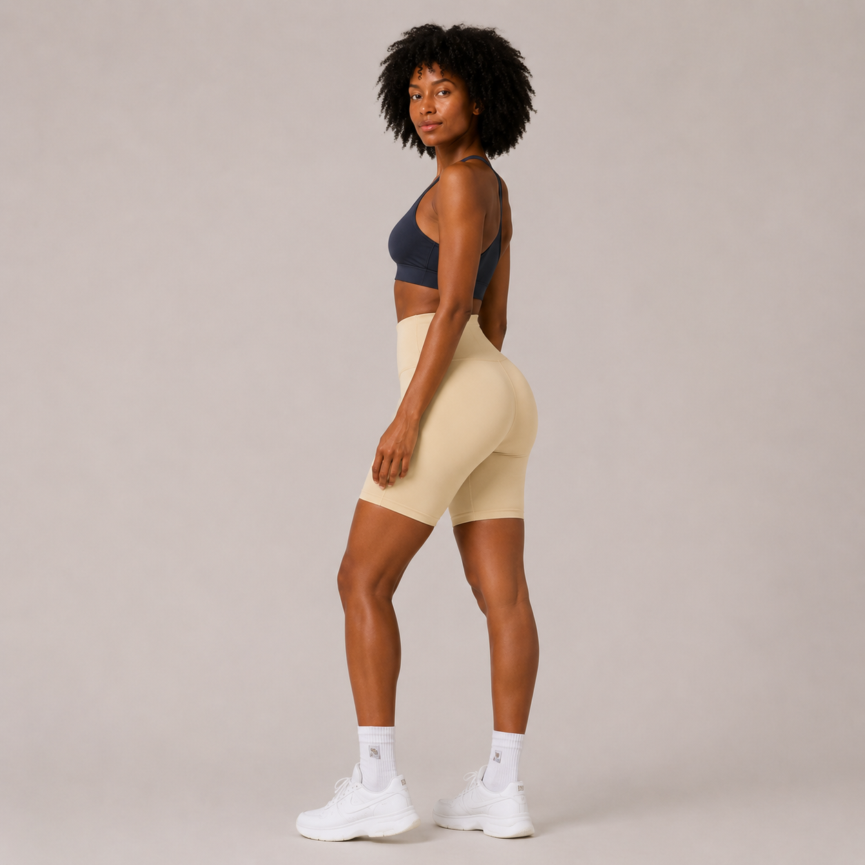 Side view of the cream Fitfigura Studio Short 8” – Flow Essential Form, showing the high-waisted fit and 8-inch short length.