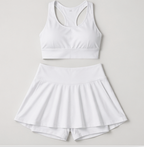 Flat lay of the Fitfigura Sway Bra Tank Set in white, featuring the bra tank top and matching pleated skirt.