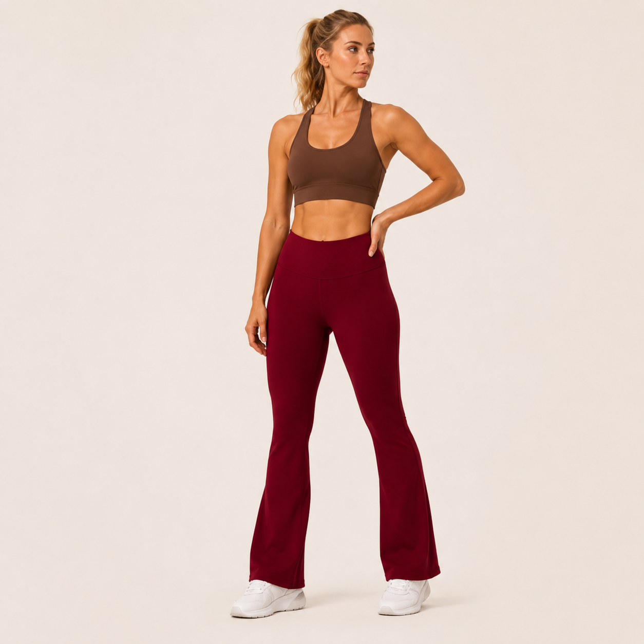 Model posing in the burgundy Fitfigura Women’s Booty Boost Yoga Flare Pant, highlighting the high-rise waistband and fitted upper leg.