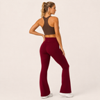 Three-quarter rear angle of the Fitfigura Women’s Booty Boost Yoga Flare Pant in burgundy, highlighting the contour fit and flared hem.