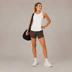 Model posing in the Fitfigura Women's in Motion Seamless Tank Top in white, highlighting the sleeveless cut and clean athletic fit.