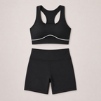 Flat lay of the black LuxeSculpt™ Active Set featuring a strappy sports bra and matching shorts.
