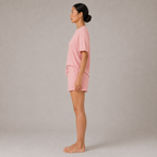 Model wearing the FitFigura Sculpt LoungeWear Set in Paradise Pink with relaxed tee and drawstring lounge shorts, side profile view