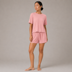 Model wearing the FitFigura Sculpt LoungeWear Set in Paradise Pink with a relaxed tee and matching lounge shorts, three-quarter view.